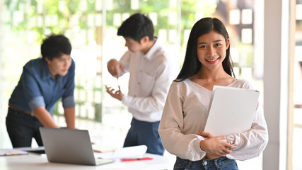 Confidently asian architect female standing on front of meeting architecture table.