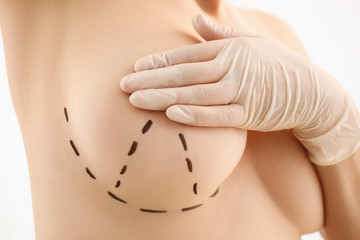 Female hand in gloves holding breast closeup