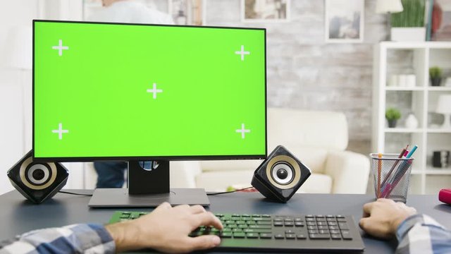 Male hands typing on green screen PC in bright and well lit space