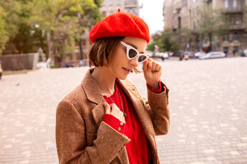 Elegant business woman wearing stylish jacket and white pants at summer day morning in the city...