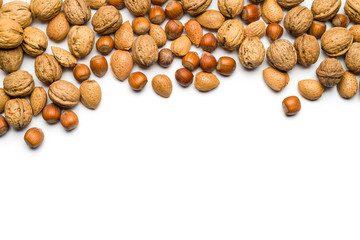 top view of mix of nuts scattered on white background with copy space