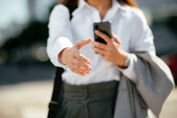 Obraz premium Close up of young businesswoman handshaking. Beautiful woman lend a hand. 