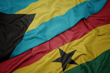 waving colorful flag of ghana and national flag of bahamas.