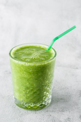 Fresh green smoothie from fruit and vegetables for a healthy lifestyle spinach, green Apple, cucumber, oatmeal isolated on bright marble background.  copy space. cafe menu. Vertical photo.
