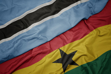 waving colorful flag of ghana and national flag of botswana.