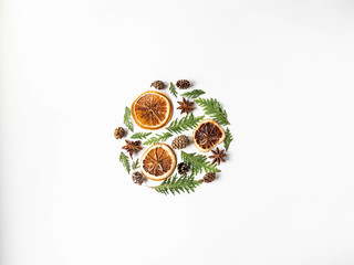 Flat lay creative natural layout circle of plants and spices. Thuja, cones, dry orange slices, spices on white background. Copy space, top view