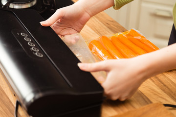 Vacuuming carrots in plastic seal bag.