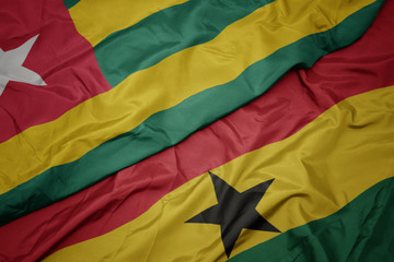waving colorful flag of ghana and national flag of togo.
