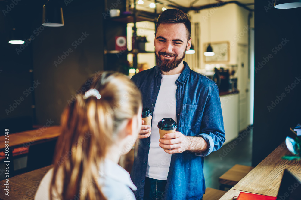 Wall mural happy bearded young man in denim outfit carry tasty coffee to go for girlfriend during meeting in st