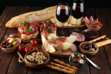Italian antipasti wine snacks set. Cheese variety, Mediterranean olives, seafood salad, Prosciutto...