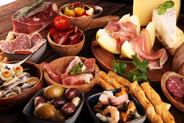 Italian antipasti wine snacks set. Cheese variety, Mediterranean olives, seafood salad, Prosciutto...