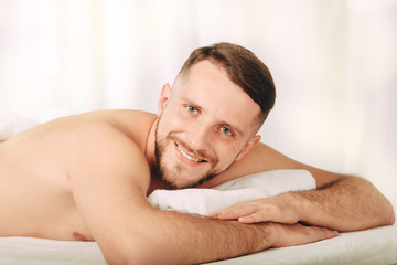 Fototapeta na wymiar Handsome man relaxing in spa ,Closeup of a positive and smiling man at wellness resort
