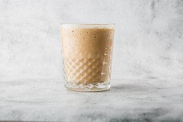 Glass with cold brew coffee and milk isolated on bright marble background. Overhead view, copy space. Advertising for cafe menu. Coffee shop menu. Horizontal photo.
