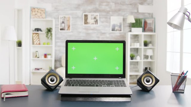 Green screen laptop on the table in room with nobody in it
