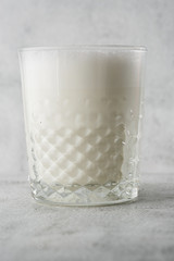 Glass of cold milk isolated on bright marble background. Overhead view, copy space. Advertising for cafe menu. Coffee shop menu. Horizontal photo.