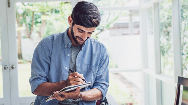 Young man writing on note book