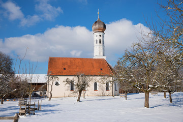 idyllic village church and apple orchard in winter