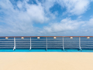 Cruise Ship Deck and railing with Ocean View in sunny day, blue sea and blue sky background.