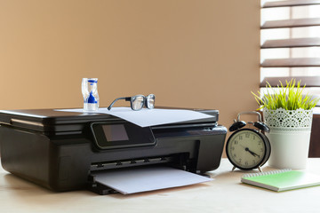 Front view of a black printer machine on a table