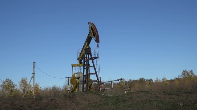 Oil well extraction pump in the wood. Mechanism operation, close-up