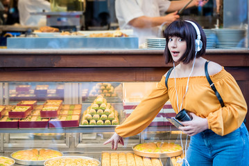 Young girl shows Turkish dessert baklava at store