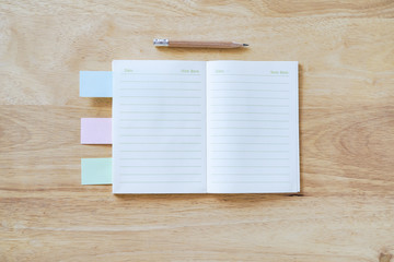 Opened blank note book with brown sharpen pencil on table, top view