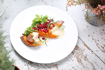 Baked sweet potato with tahini sauce and pomegranate.