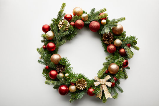 Top view of festive Christmas wreath with baubles on white background