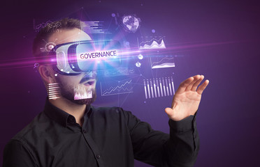 Businessman looking through Virtual Reality glasses with GOVERNANCE inscription, new business concept