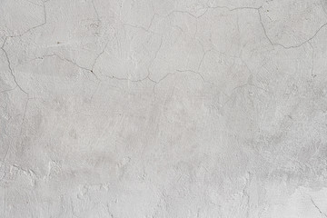Obraz premium Rough white relief stucco with cracks wall texture background. blank for designers