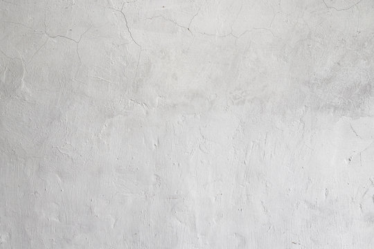 Rough white relief stucco with cracks wall texture background. blank for designers