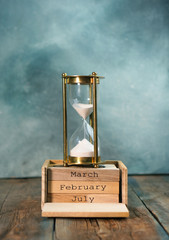 Countdown. Hourglass on a wooden calendar. Time runs concept.