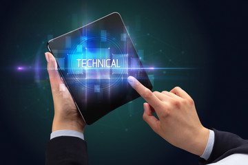 Obraz premium Businessman holding a foldable smartphone with TECHNICAL inscription, new technology concept