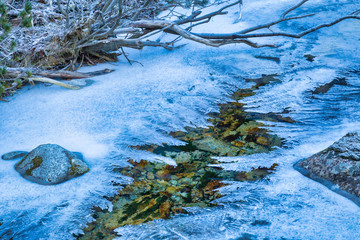 Frozen wild creek in winter. The High Tatras National Park, Slovakia, Europe.
