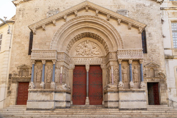 Ornate door of a carved stone church with columns in Arles in Provence, France