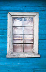 Grungy window in blue wooden wall