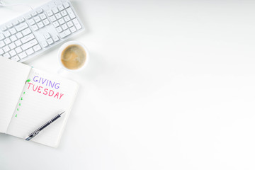 Notepad for To-Do list Giving Tuesday. White paper ready to write notes to various helping on Tuesday. International Charity Aid Day, giving hashtag activity. On a white desktop flatlay copy space