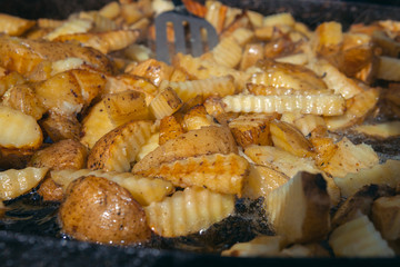 Top view of Roast potatoes in a large pan. Delicious food at the festival. Field kitchen at the hearth. lovely delicious and appetizing, yummy, background texture