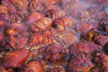 Obraz na płótnie Canvas pig knuckles, traditional Ukrainian delicatessen. meat is cooked at festivals in a large frying pan on fire