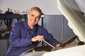 KFZ Mechaniker beim Reparieren von Auto Motor