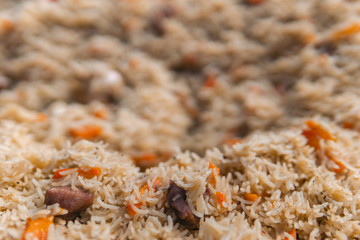 Texture of pilaf, Beautiful rice, with a pod of red pepper and a chapel’s head, a spoon, appetizing and tasty food, close up selective focus