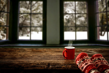 Woman legs with jeans and christmas socks on wooden dark table.Free space for your decoration and...