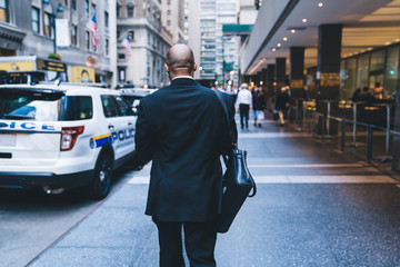 African American worker walking down street