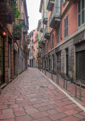 a narrow street in the historic center of Milan with nineteenth-century stone paving