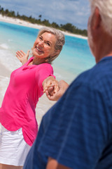 Fototapeta na wymiar Romantic senior Caucasian couple dancing on beach together