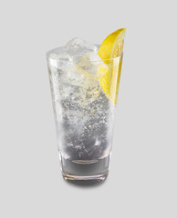 Iced cocktail with slice of lemon on transparent glass isolated in white background