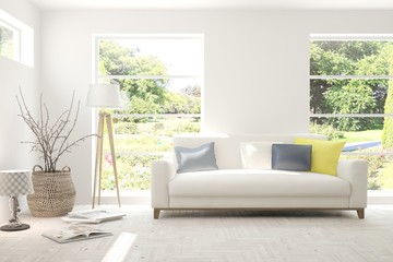 Stylish room in white color with sofa and summer landscape in window. Scandinavian interior design. 3D illustration