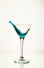 A splash of blue alcohol in a Martini glass