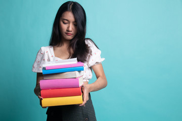 Unhappy young Asian woman studying  with may books