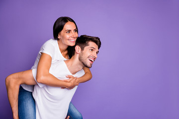 Turned photo of cute cheerful nice stylish trendy couple of people smiling toothily piggyback girl riding her boyfriend look empty space isolated pastel violet color background